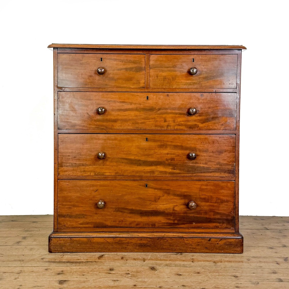 A 19th-century mahogany chest of drawers featuring two short drawers over three long drawers with turned wooden knobs and a solid plinth base.