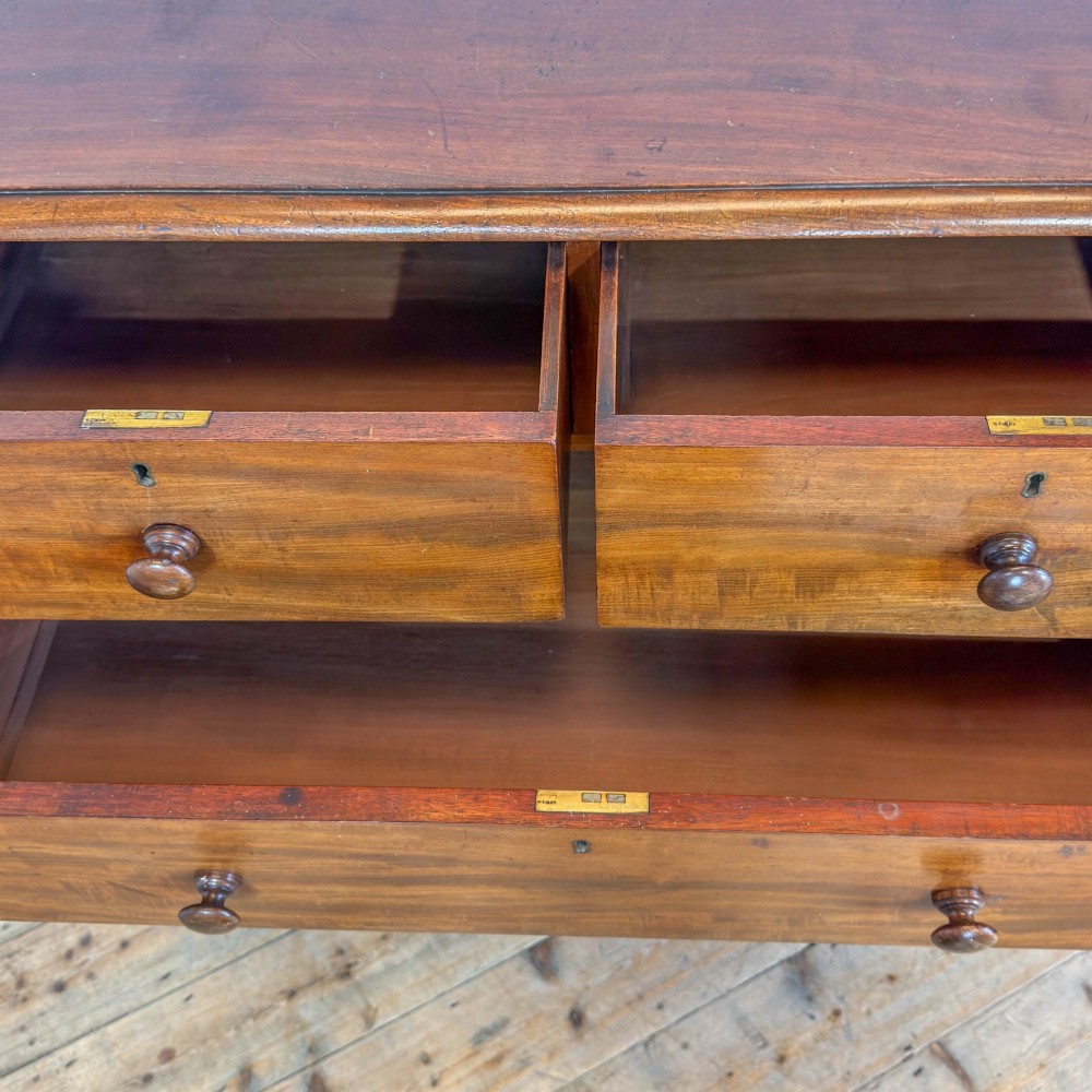 A 19th-century mahogany chest of drawers featuring two short drawers over three long drawers with turned wooden knobs and a solid plinth base. View VIII