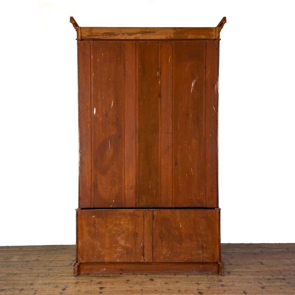 A tall Victorian mahogany wardrobe featuring an arched central mirrored door flanked by wooden side panels over a wide base drawer. View IX
