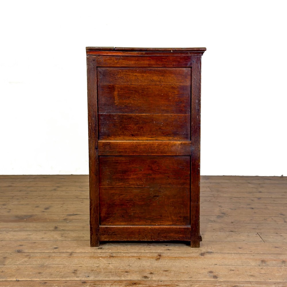 An early nineteenth-century dark oak dresser base featuring multiple drawers with brass handles, twin panelled cupboard doors, and a solid wood plinth base. View VIII