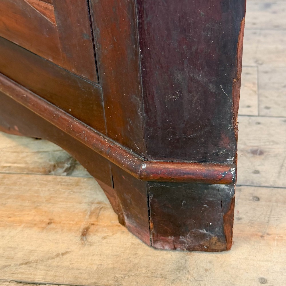 A tall two-part mahogany corner cabinet featuring geometric astragal glazed upper doors above panelled lower doors. View VI