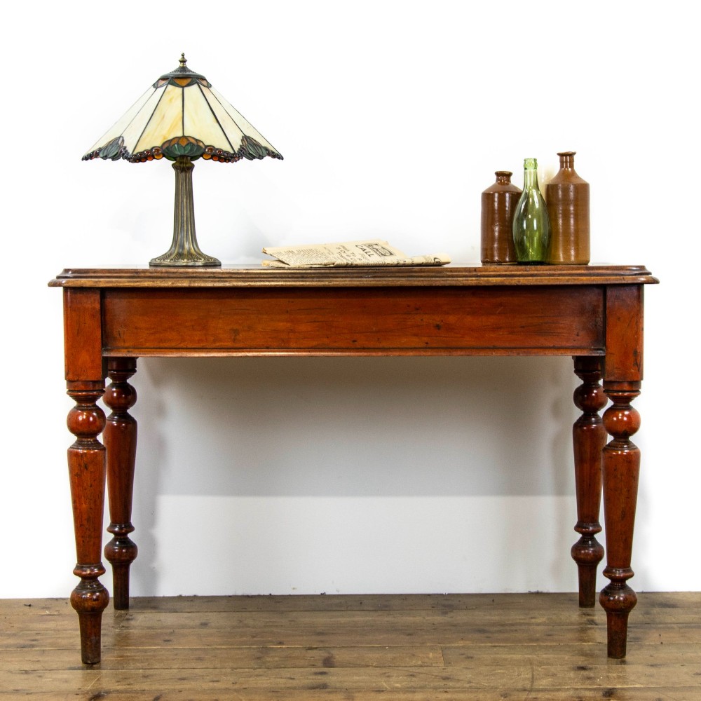An antique mahogany console table featuring a rectangular top with moulded edges supported by four turned wooden legs.