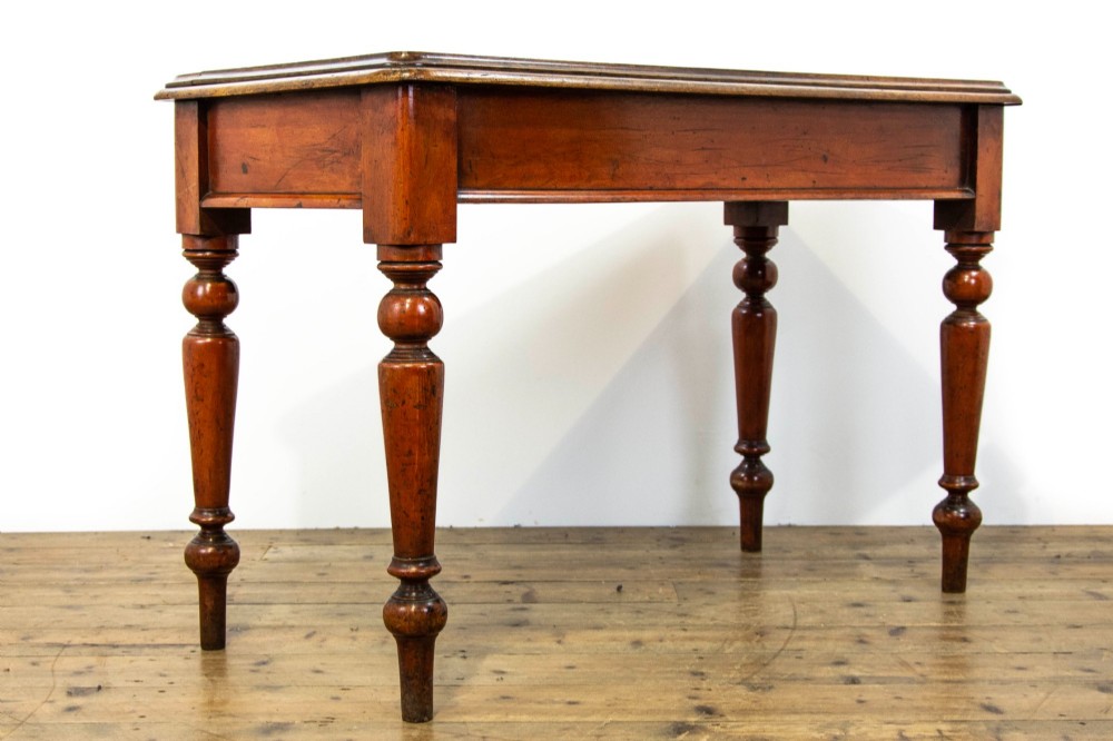 An antique mahogany console table featuring a rectangular top with moulded edges supported by four turned wooden legs. View IV