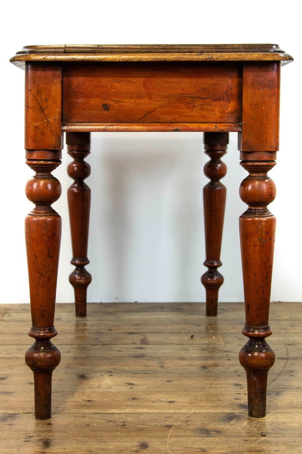 An antique mahogany console table featuring a rectangular top with moulded edges supported by four turned wooden legs. View VI