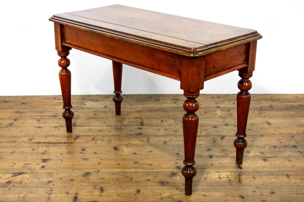 An antique mahogany console table featuring a rectangular top with moulded edges supported by four turned wooden legs. View VII