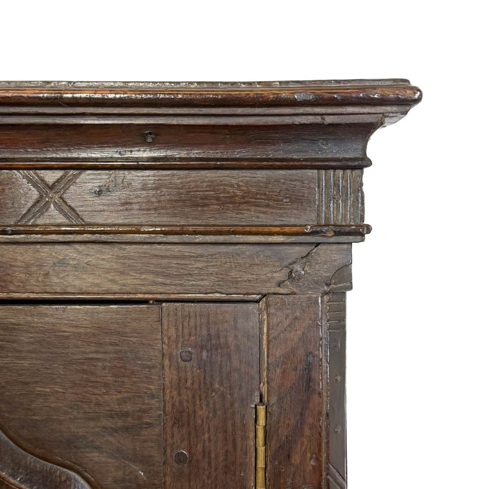 An 18th-century Welsh dark oak Carmarthenshire coffer featuring upper cupboard doors with pointed arch fielded panels above multiple drawers fitted with brass knobs. View XII
