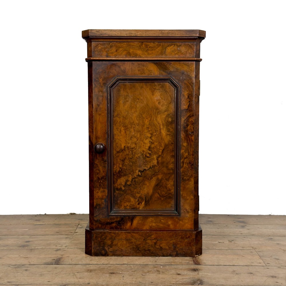 A Victorian burr walnut pot cupboard featuring a single panelled door with a turned wooden knob, chamfered corners, and a solid plinth base.