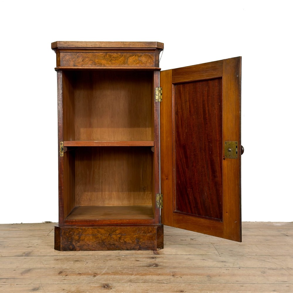 A Victorian burr walnut pot cupboard featuring a single panelled door with a turned wooden knob, chamfered corners, and a solid plinth base. View II