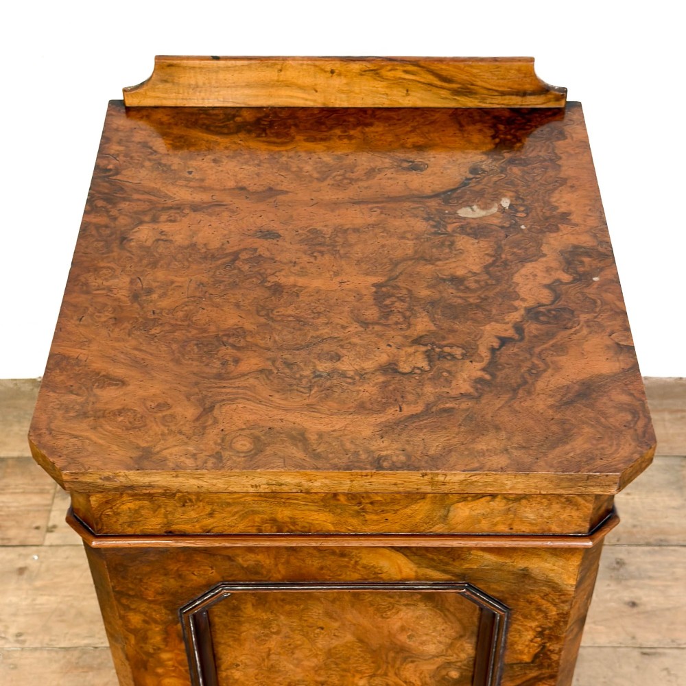 A Victorian burr walnut pot cupboard featuring a single panelled door with a turned wooden knob, chamfered corners, and a solid plinth base. View IX