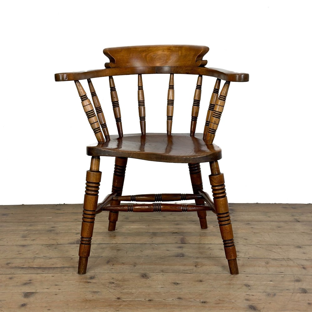 A warm brown wooden smokers bow armchair featuring turned legs, vertical back spindles, a steam-bent curved top rail, and a shaped solid seat. View III
