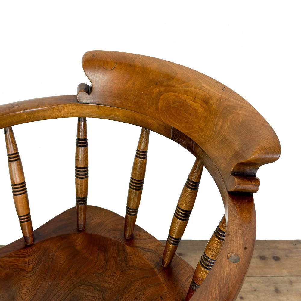 A warm brown wooden smokers bow armchair featuring turned legs, vertical back spindles, a steam-bent curved top rail, and a shaped solid seat. View VII