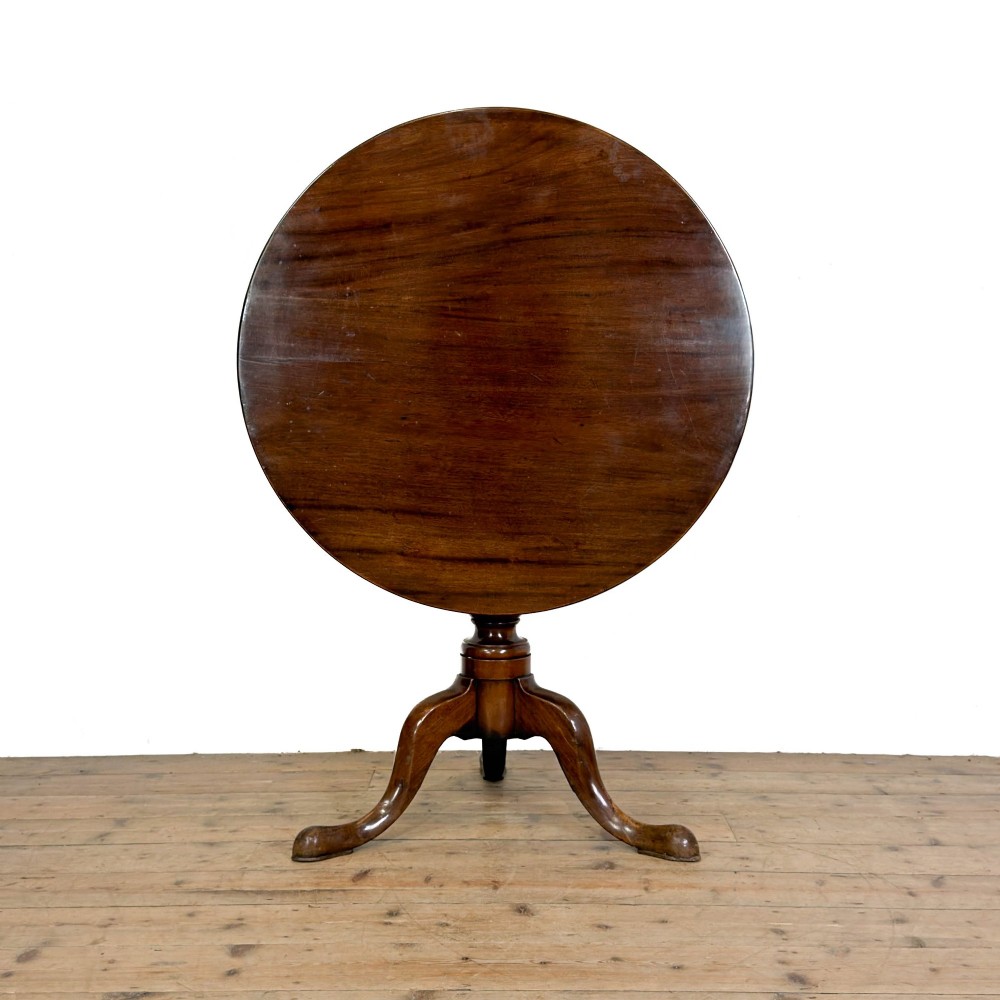 An antique mahogany tilt-top occasional table featuring a round circular top, turned central column pedestal, and three splayed cabriole legs with pad feet. View III