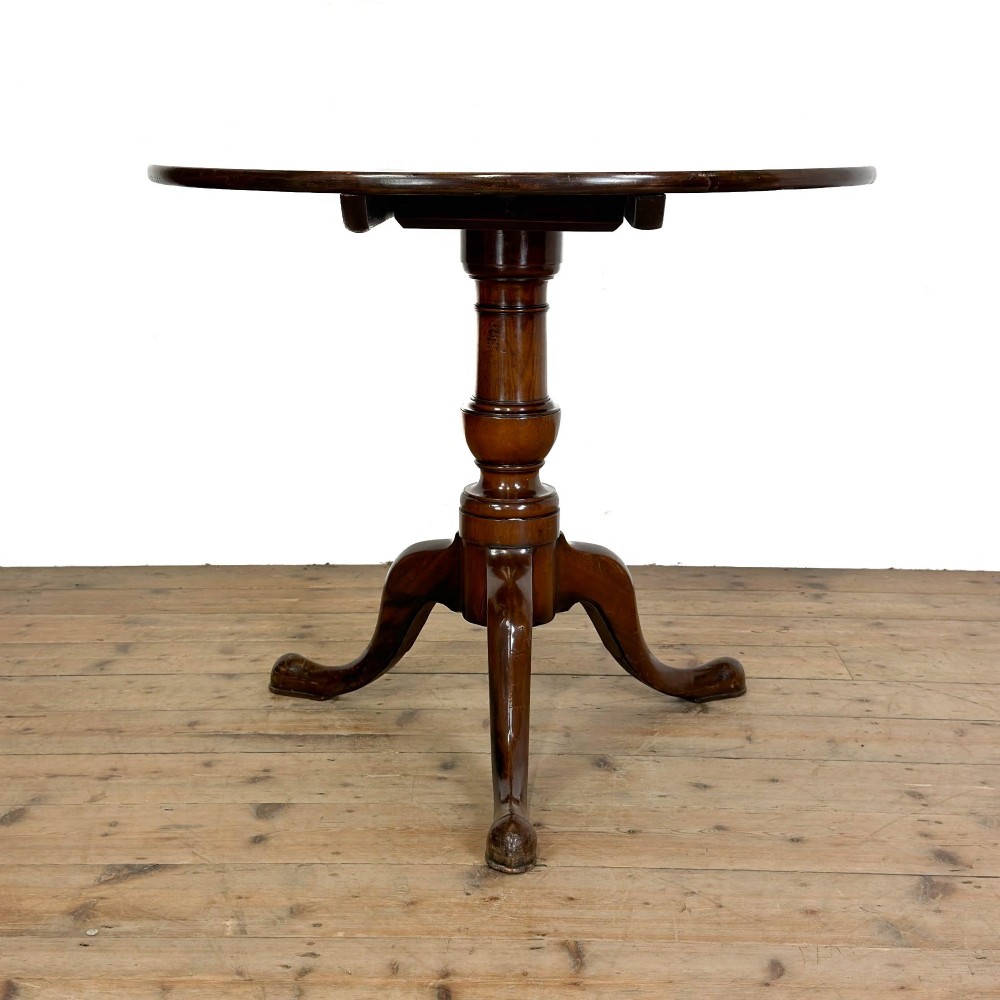 An antique mahogany tilt-top occasional table featuring a round circular top, turned central column pedestal, and three splayed cabriole legs with pad feet. View XI