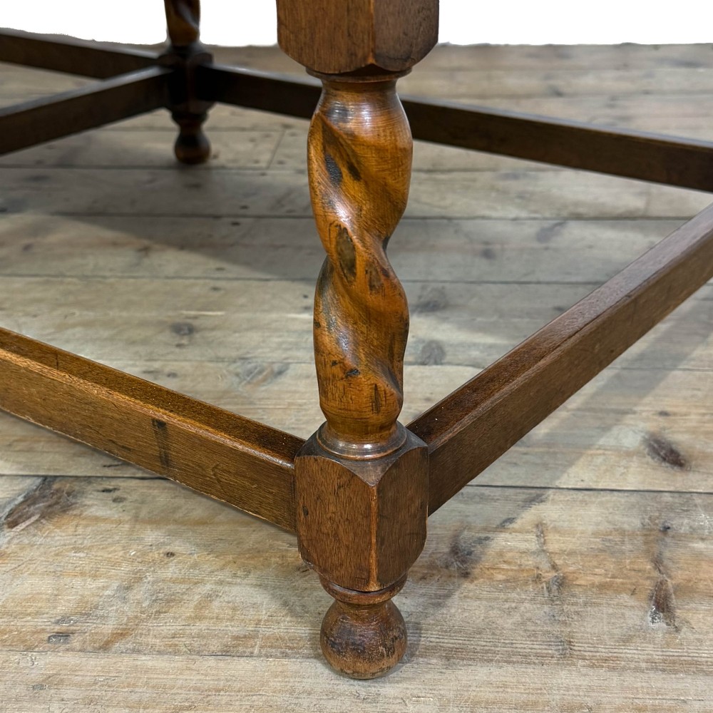 An Arts and Crafts style oak hall bench featuring barley twist legs and side posts, a vertical slat backrest, and a terracotta-coloured cushion. View II