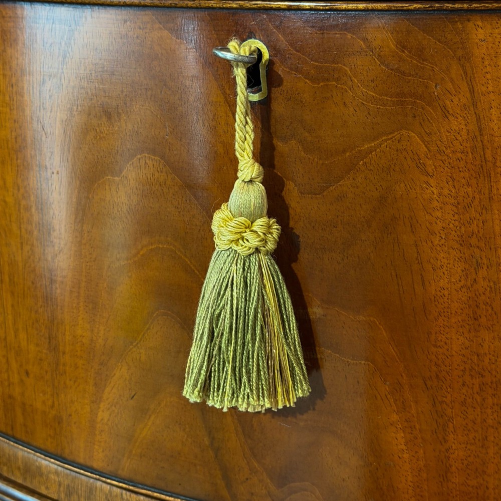 A tall mahogany serpentine chest on chest featuring two stacked sections of graduating drawers with brass handles and carved cornice detail. View VI