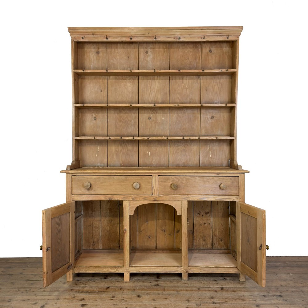 A tall Victorian pine kitchen dresser with open plate shelving, cup hooks, two drawers, panelled doors, and a central open alcove. View II
