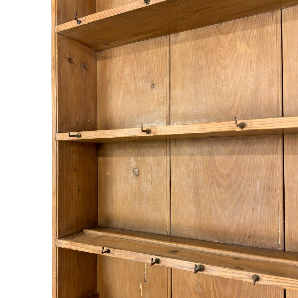 A tall Victorian pine kitchen dresser with open plate shelving, cup hooks, two drawers, panelled doors, and a central open alcove. View III