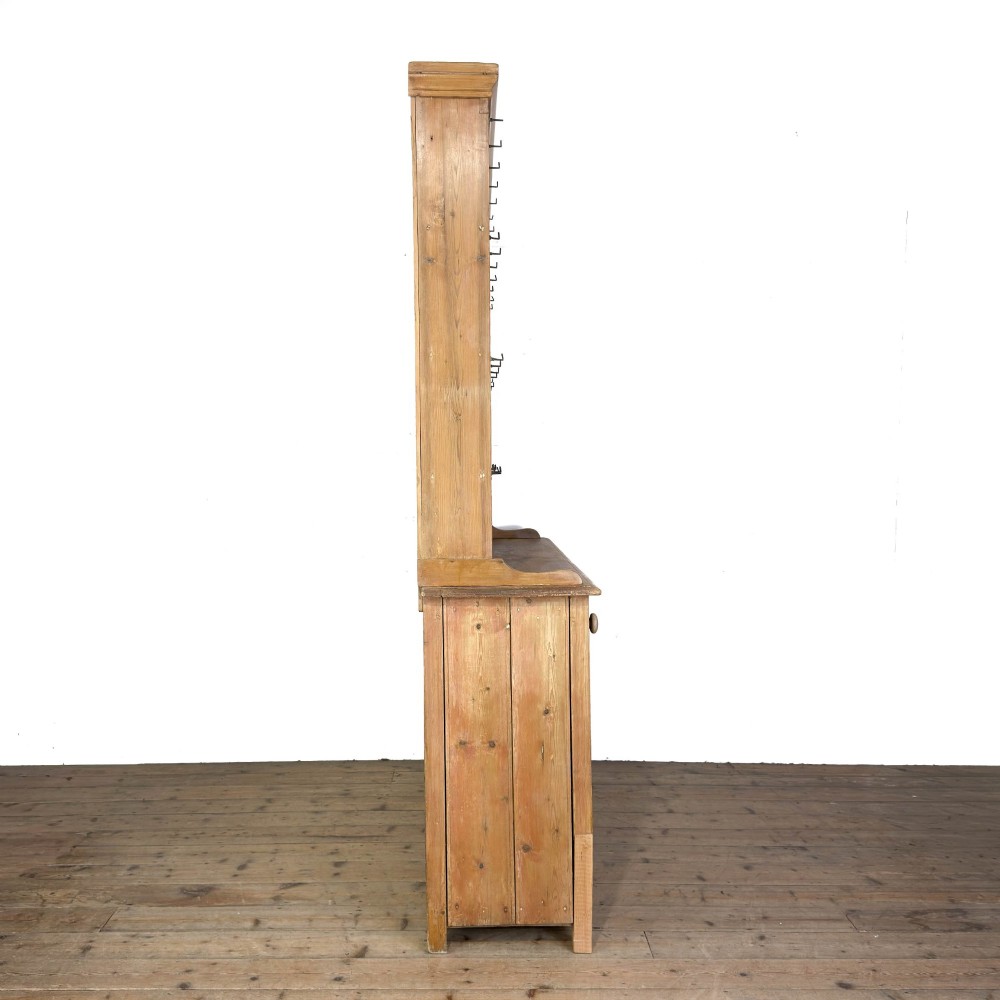 A tall Victorian pine kitchen dresser with open plate shelving, cup hooks, two drawers, panelled doors, and a central open alcove. View V