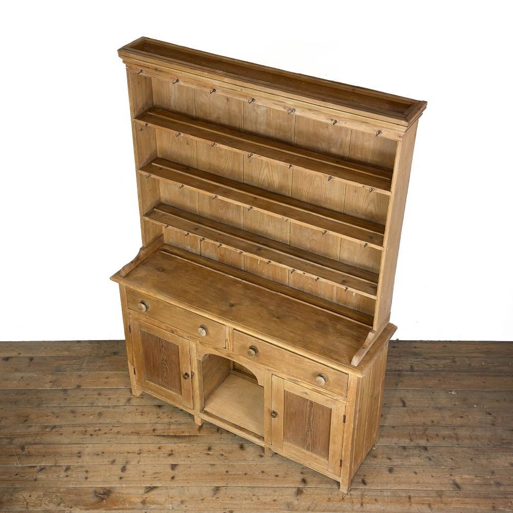 A tall Victorian pine kitchen dresser with open plate shelving, cup hooks, two drawers, panelled doors, and a central open alcove. View VI