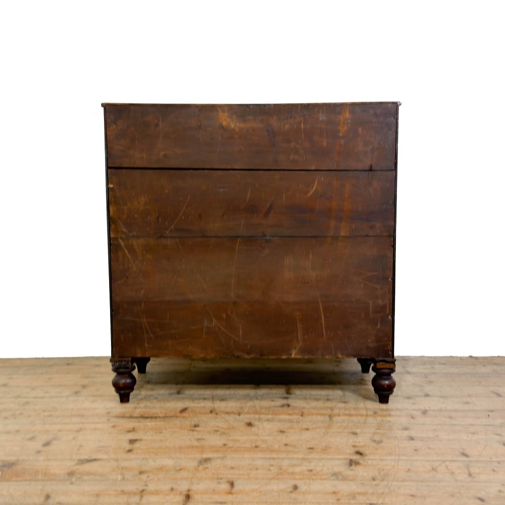 A Victorian mahogany bow front chest of drawers with two short over three long drawers, turned wooden knobs, and turned feet. View VI