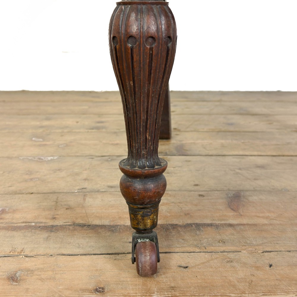 A 19th-century Anglo-Indian chair with an intricately hand-carved lattice backrest, dark wood frame, turned legs on castors, and a patterned red upholstered seat. View III