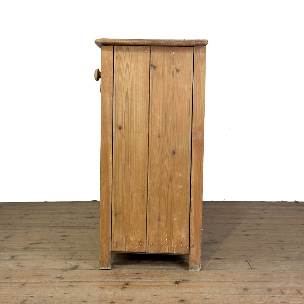 A Victorian pine dresser base featuring two top drawers with turned wooden knobs above two panelled cupboard doors and a central open arched niche. View VI