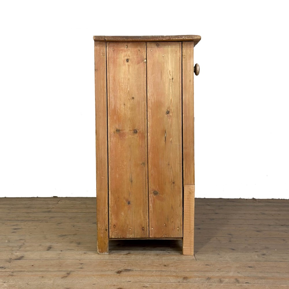 A Victorian pine dresser base featuring two top drawers with turned wooden knobs above two panelled cupboard doors and a central open arched niche. View IX