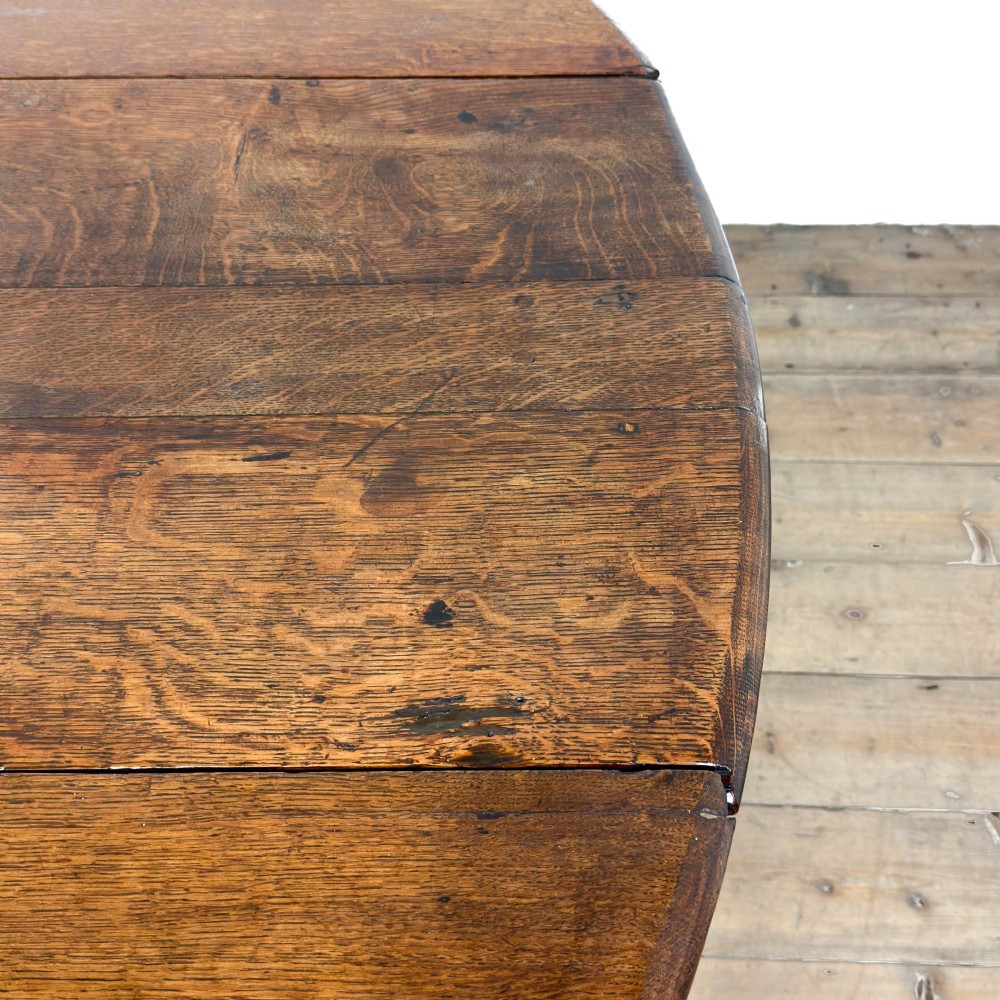 An 18th-century dark oak gateleg table featuring two hinged drop leaves, turned legs, and lower stretchers. View IX