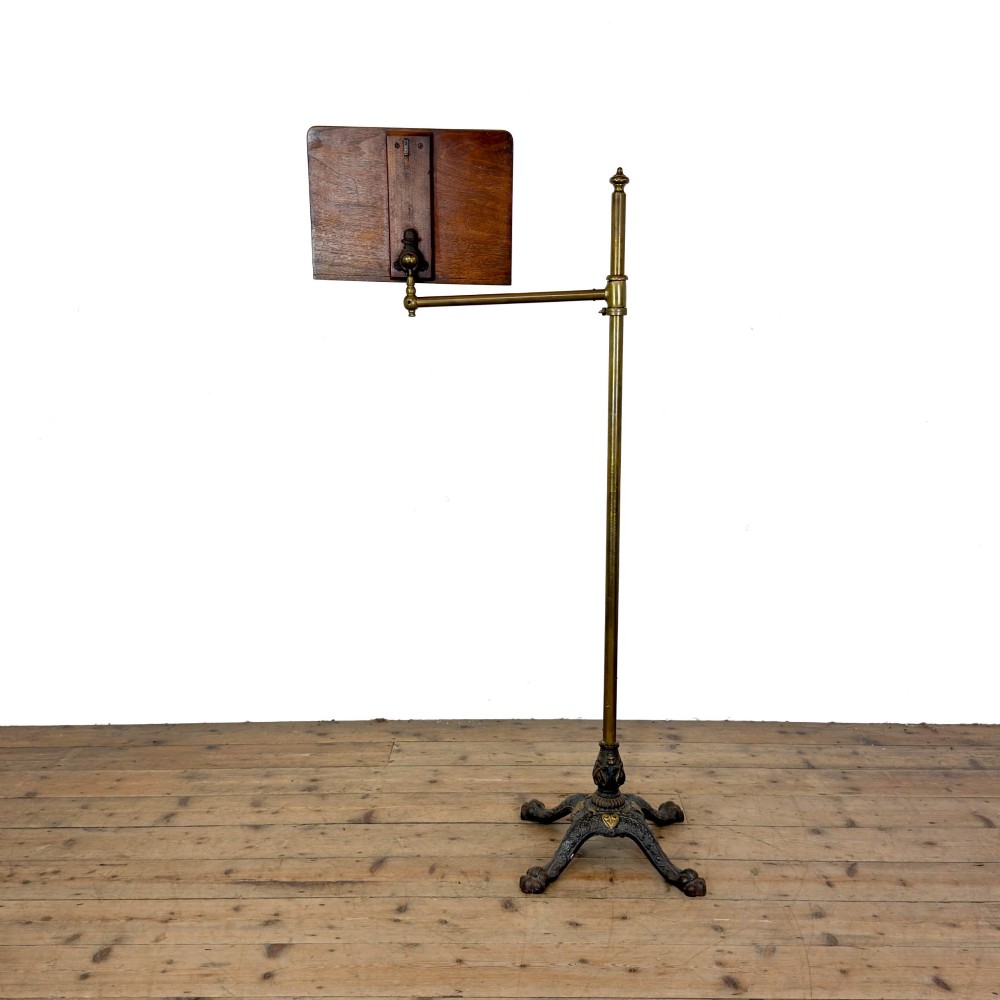 A Victorian adjustable reading stand featuring a cast iron decorative base, a brass column with an articulated swing arm, and a rectangular mahogany book rest. View IV