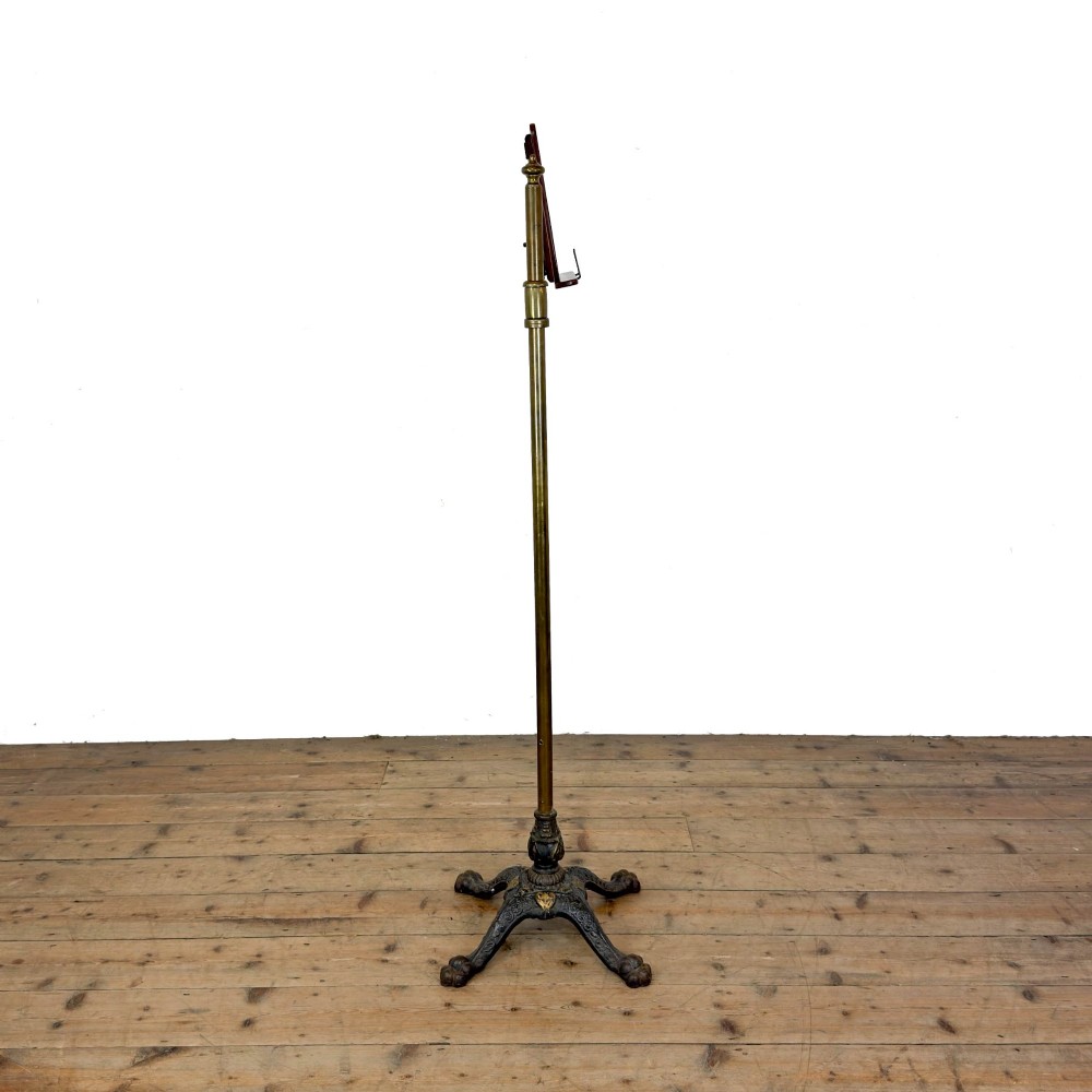 A Victorian adjustable reading stand featuring a cast iron decorative base, a brass column with an articulated swing arm, and a rectangular mahogany book rest. View VIII