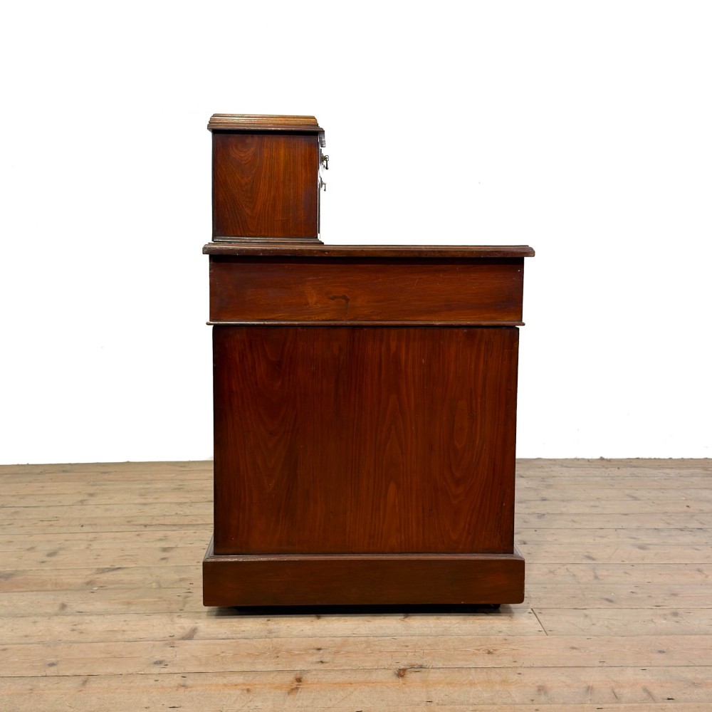 An antique Victorian mahogany pedestal desk featuring a raised gallery superstructure, multiple drawers, and brass handles. View IV