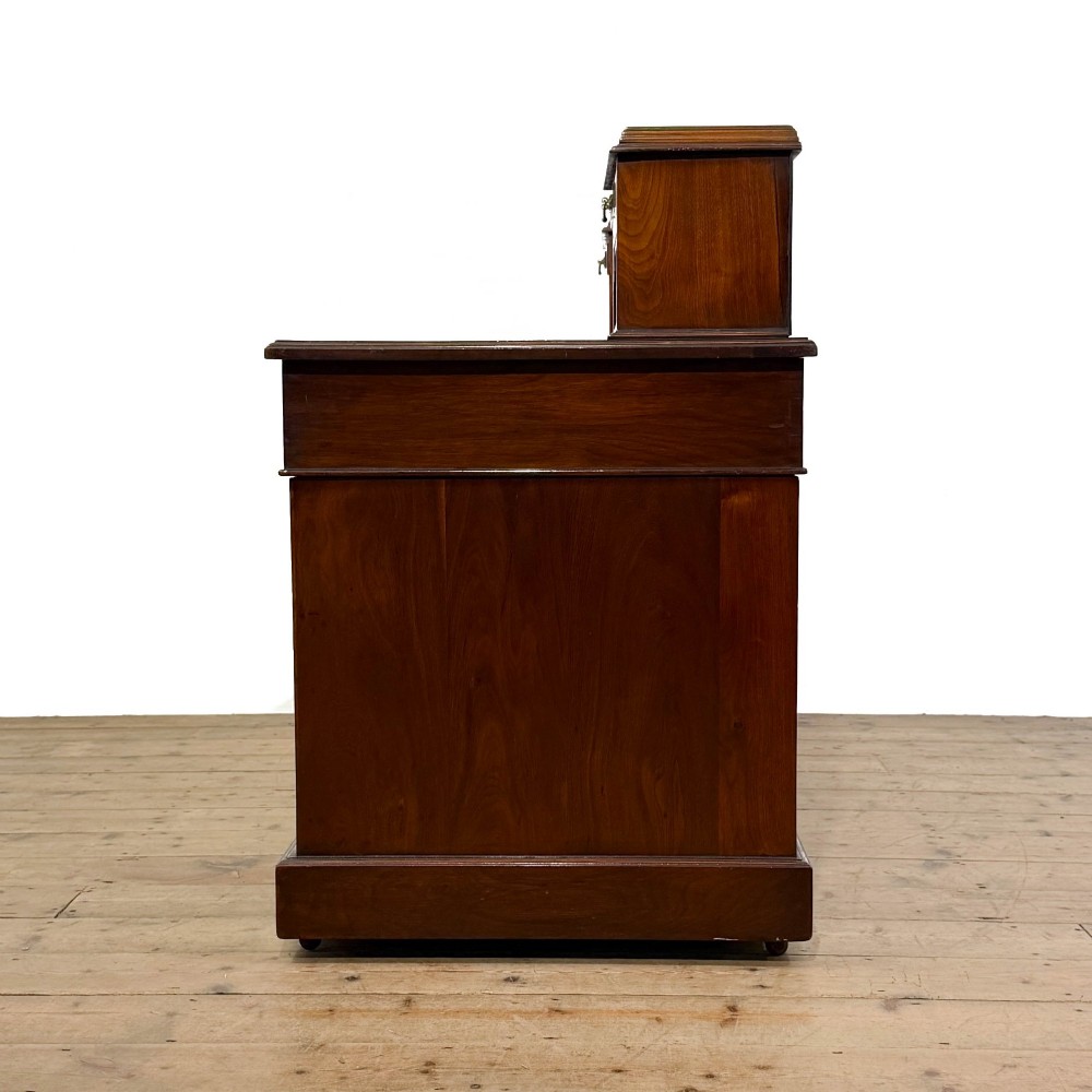 An antique Victorian mahogany pedestal desk featuring a raised gallery superstructure, multiple drawers, and brass handles. View V