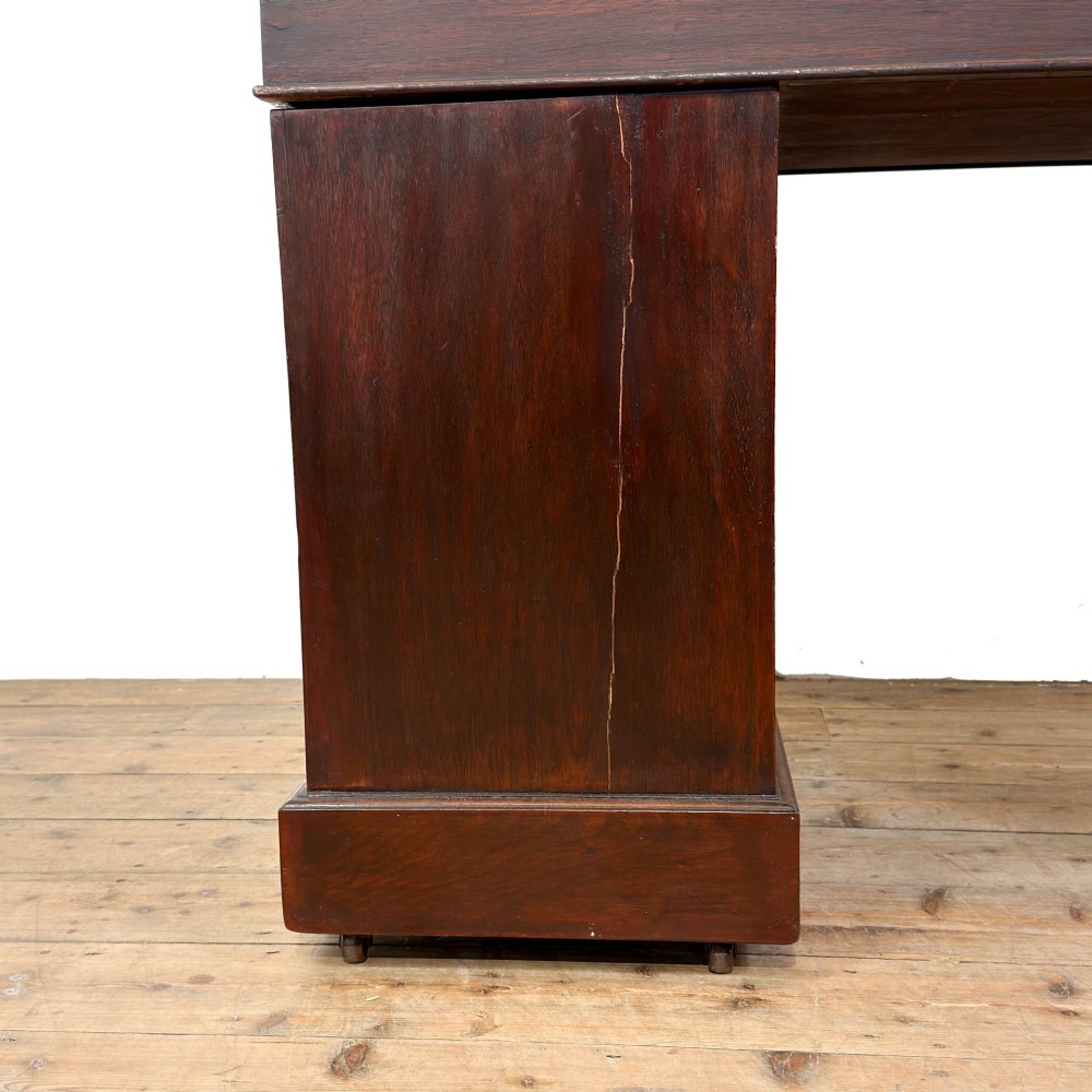 An antique Victorian mahogany pedestal desk featuring a raised gallery superstructure, multiple drawers, and brass handles. View VIII