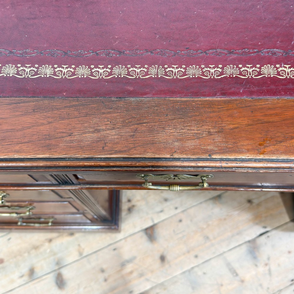 An antique Victorian mahogany pedestal desk featuring a raised gallery superstructure, multiple drawers, and brass handles. View X