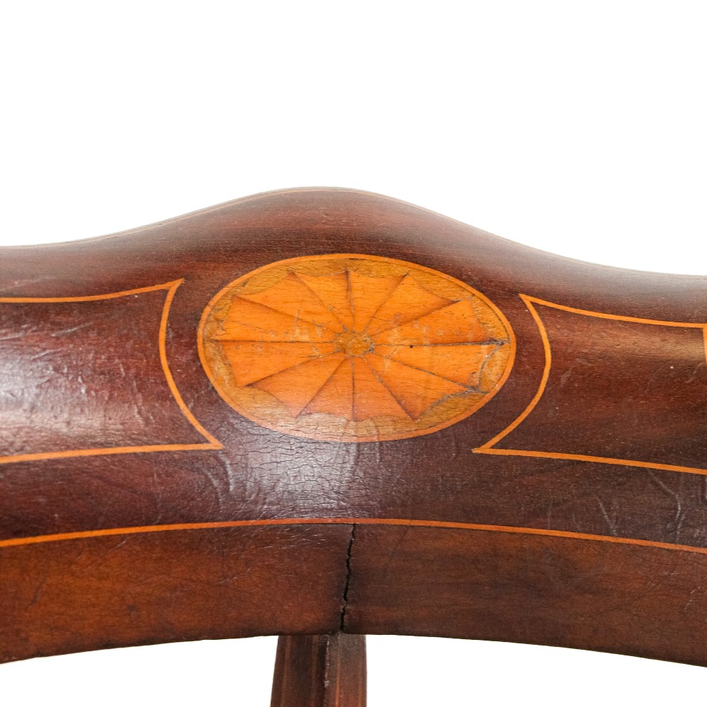 An antique Edwardian mahogany corner armchair featuring inlaid marquetry oval patera, two pierced back splats, tapered legs, and a patterned fabric seat. View VII