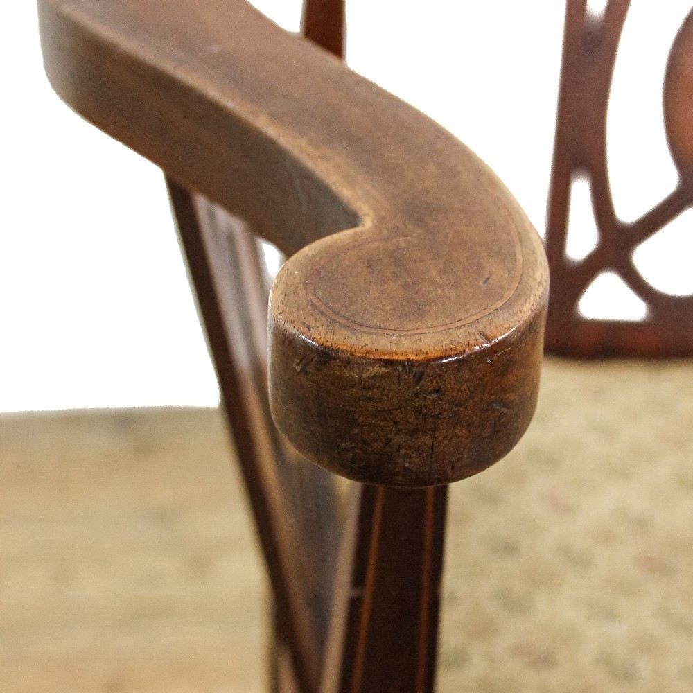An antique Edwardian mahogany corner armchair featuring inlaid marquetry oval patera, two pierced back splats, tapered legs, and a patterned fabric seat. View VIII