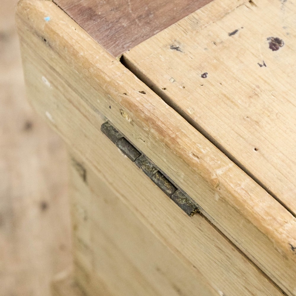A rectangular natural pine storage chest featuring visible hand-cut dovetail joinery, a fitted flat lid, a central keyhole escutcheon, and a thick timber plinth base. View IV