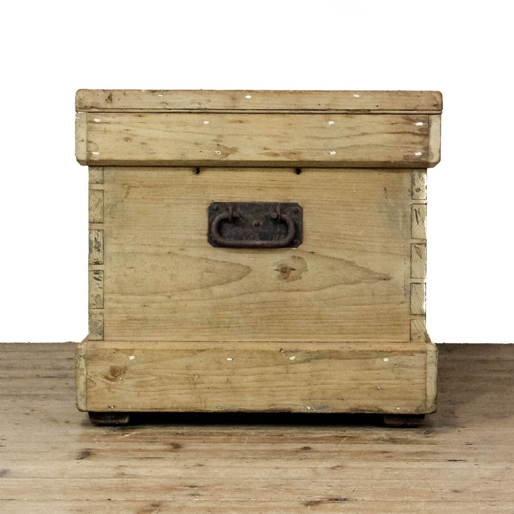 A rectangular natural pine storage chest featuring visible hand-cut dovetail joinery, a fitted flat lid, a central keyhole escutcheon, and a thick timber plinth base. View V