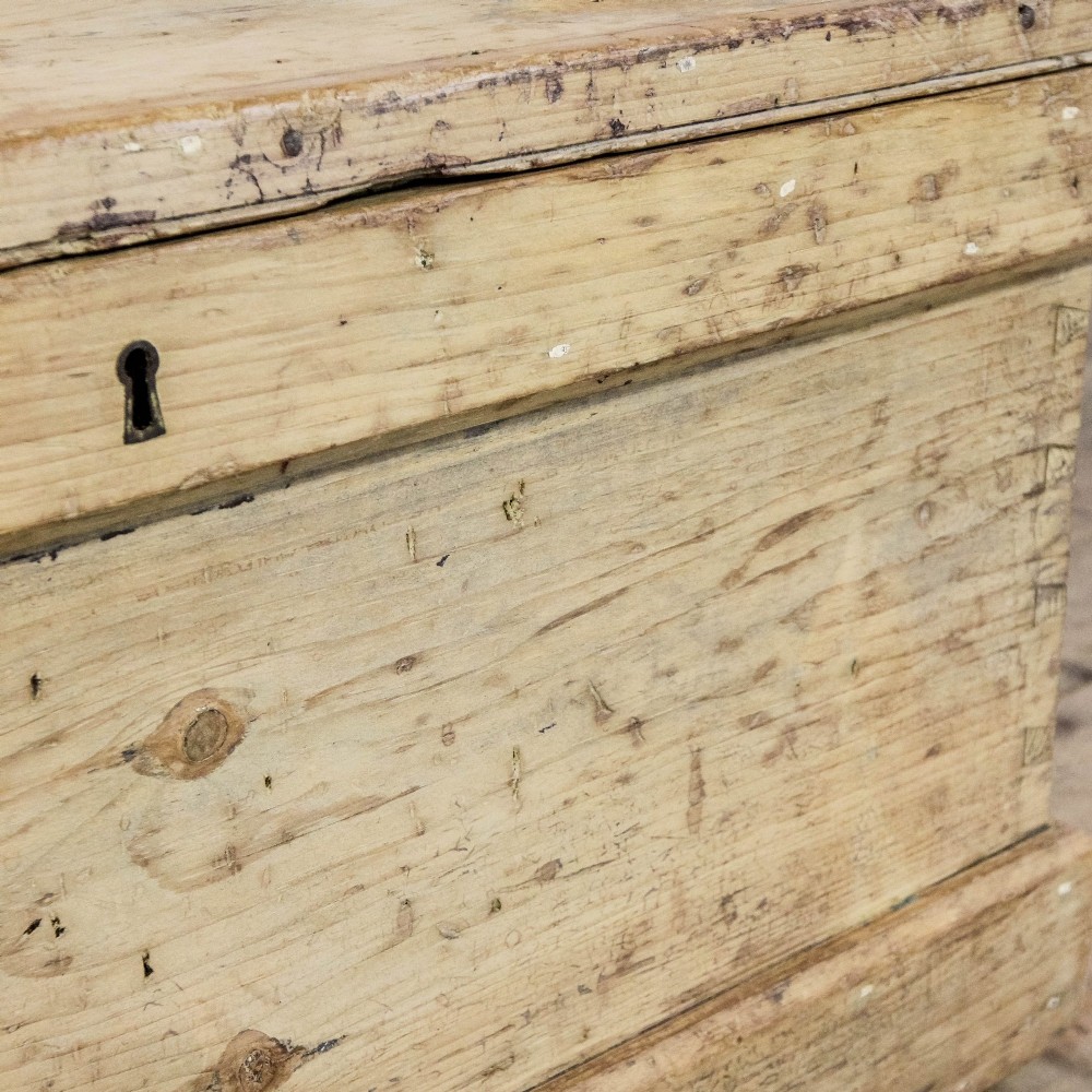 A rectangular natural pine storage chest featuring visible hand-cut dovetail joinery, a fitted flat lid, a central keyhole escutcheon, and a thick timber plinth base. View VIII