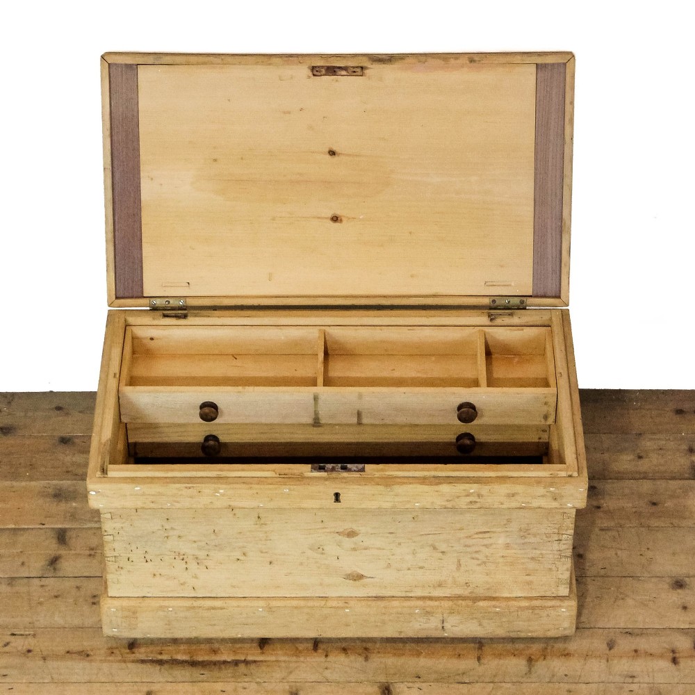 A rectangular natural pine storage chest featuring visible hand-cut dovetail joinery, a fitted flat lid, a central keyhole escutcheon, and a thick timber plinth base. View XI