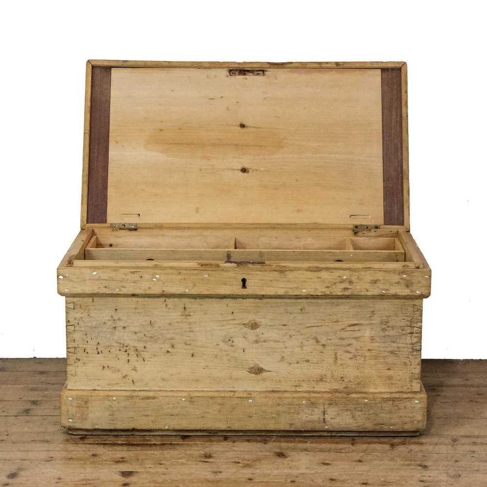 A rectangular natural pine storage chest featuring visible hand-cut dovetail joinery, a fitted flat lid, a central keyhole escutcheon, and a thick timber plinth base. View XII