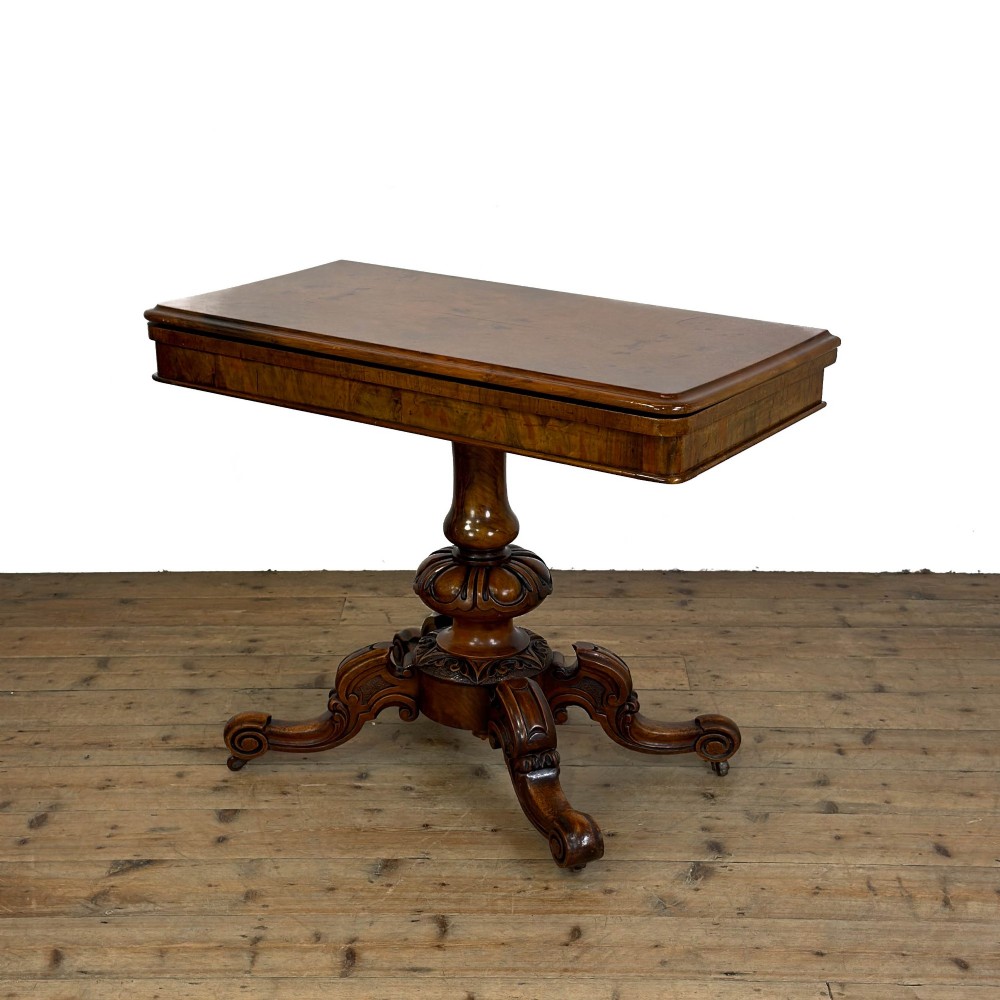 An antique Victorian walnut foldover card table featuring a rectangular swivel top, turned central column, and carved scroll feet. View III