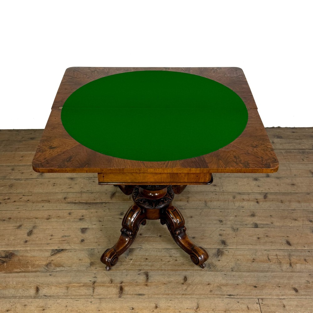 An antique Victorian walnut foldover card table featuring a rectangular swivel top, turned central column, and carved scroll feet. View VII