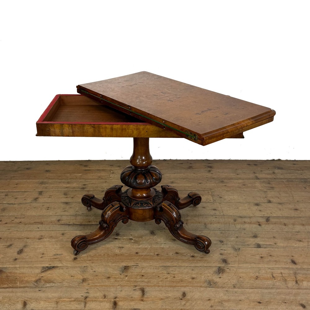 An antique Victorian walnut foldover card table featuring a rectangular swivel top, turned central column, and carved scroll feet. View VIII