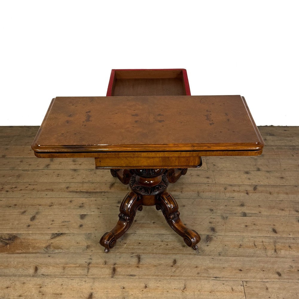 An antique Victorian walnut foldover card table featuring a rectangular swivel top, turned central column, and carved scroll feet. View XI