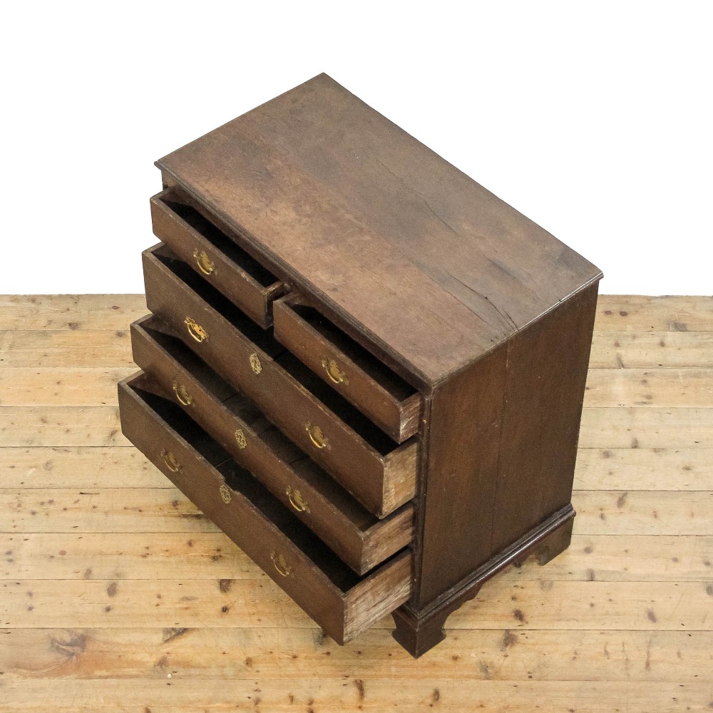An eighteenth-century dark oak chest of drawers featuring a two-over-three drawer configuration, brass swan-neck handles, decorative keyhole escutcheons, and shaped bracket feet. View VI