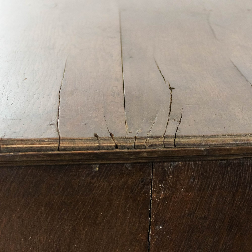 An eighteenth-century dark oak chest of drawers featuring a two-over-three drawer configuration, brass swan-neck handles, decorative keyhole escutcheons, and shaped bracket feet. View VIII