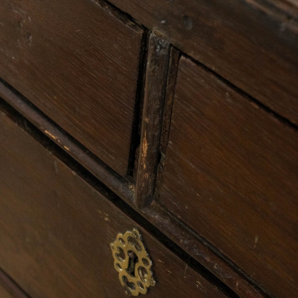 An eighteenth-century dark oak chest of drawers featuring a two-over-three drawer configuration, brass swan-neck handles, decorative keyhole escutcheons, and shaped bracket feet. View IX