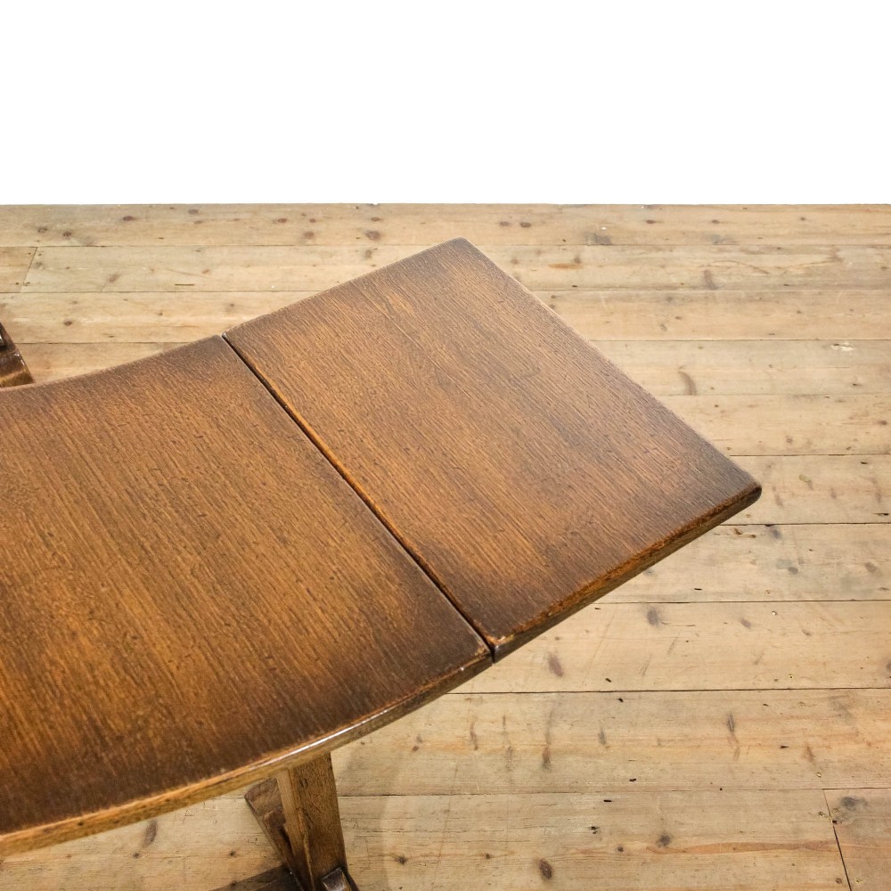 An antique dark oak horseshoe-shaped hunt table featuring upright trestle supports and a curved base stretcher. View VI