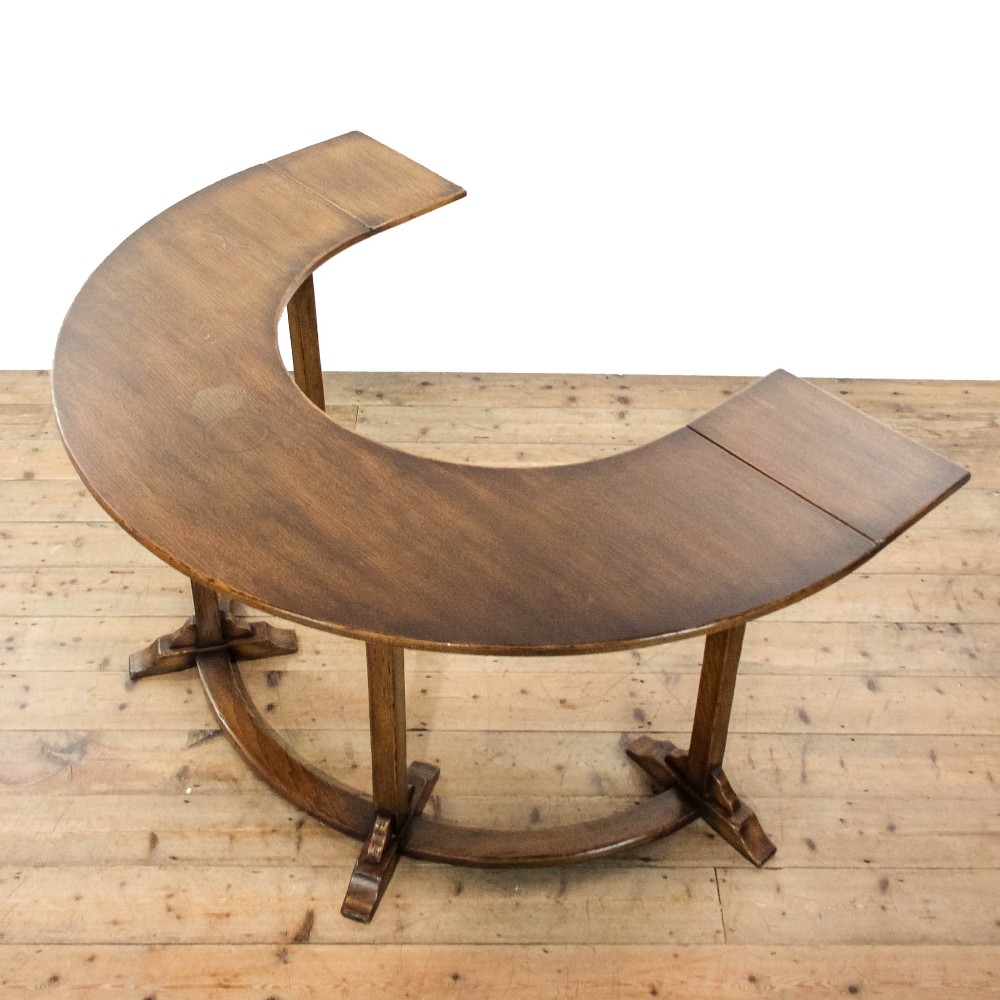An antique dark oak horseshoe-shaped hunt table featuring upright trestle supports and a curved base stretcher. View VIII
